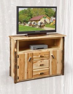 an entertainment center made out of wood with a television on it's stand and drawers