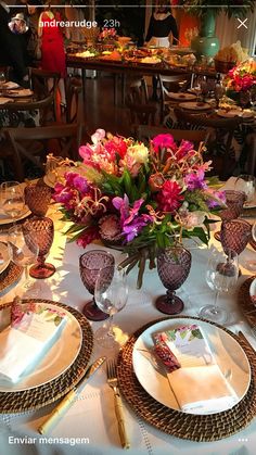 the table is set with flowers and place settings