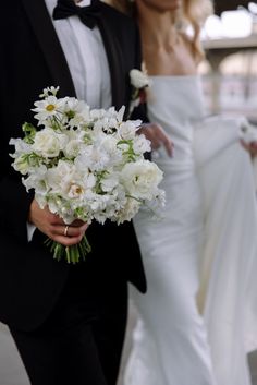 the bride and groom are holding their bouquets