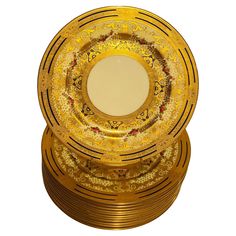 a stack of gold colored plates sitting on top of each other in front of a white background