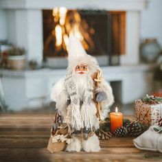 there is a small white troll standing next to a christmas tree and presents on the table