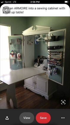 an open cabinet in the middle of a room with clothes hanging on hooks and shelves