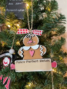 an ornament hanging from the top of a christmas tree with a gingerbread man on it