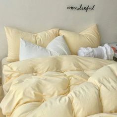 an unmade bed with several pillows on it