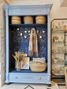 a blue cabinet with baskets and other items on it