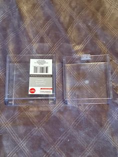 two clear plastic boxes sitting on top of a bed