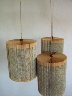 three lamps made out of bamboo sticks hanging from strings on the wall next to each other