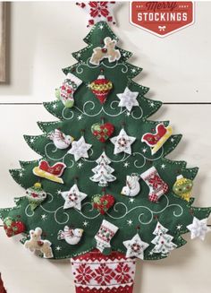 a christmas tree made out of felt is hanging on the wall