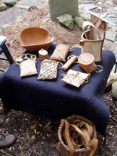 a table topped with lots of items on top of a field covered in dirt and grass