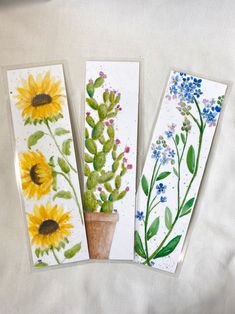 three cards with flowers and plants painted on them