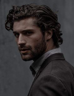 a black and white photo of a man with curly hair