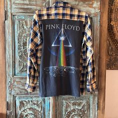 a pink floyd shirt hanging on a wooden door