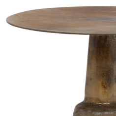 a round wooden table sitting on top of a white floor next to a metal pole