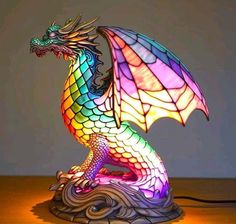 a colorful dragon lamp sitting on top of a wooden table