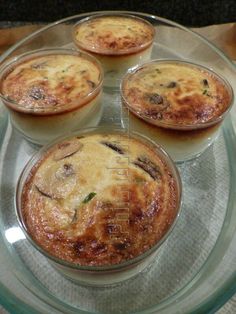 four small pies sitting on top of a glass plate