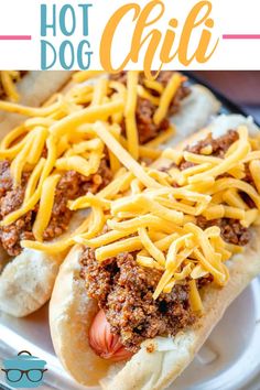 two hot dogs covered in cheese and chili on a white plate with text overlay