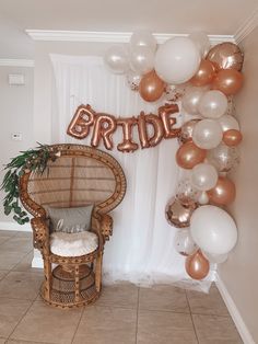 a chair and balloon arch with the word bride on it