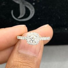 a person holding a diamond ring in their hand