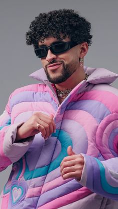 a man with curly hair wearing sunglasses and a puffy jacket