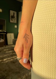 a woman's hand with a small tattoo on it