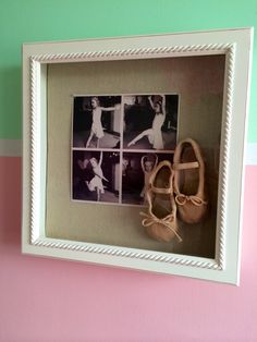 a pair of ballet shoes are hanging in a shadow box