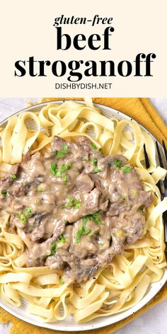 a white plate topped with beef stroganoni next to a fork and yellow napkin