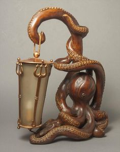 an octopus statue holding a bucket with it's trunk in the shape of a cup