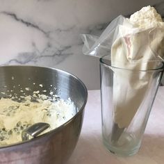 a mixing bowl with some food in it next to a large glass cup filled with batter