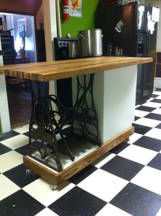 an old fashioned sewing machine on display in a room with checkered flooring and green walls