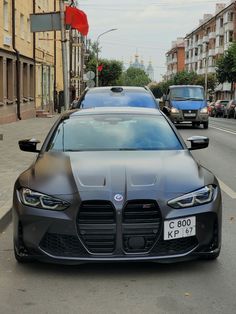 a black sports car is parked on the side of the road in front of other cars