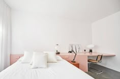 a white bed sitting next to a pink desk