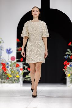 a model walks down the runway in a short dress