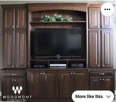 a large entertainment center with a flat screen tv on it's stand and cabinets