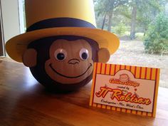 a toy monkey with a hat on top of it next to a sign that says jr robinson