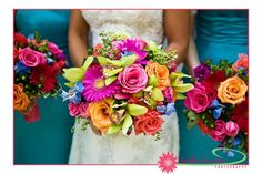 the bridesmaids are holding their bouquets with bright colored flowers on them,