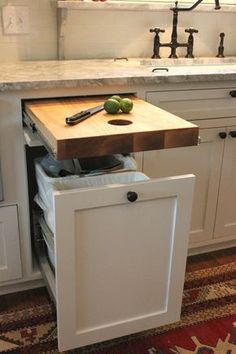 a kitchen with an island and cutting board in the middle, on top of a rug