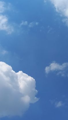 an airplane is flying high in the blue sky with white clouds behind it and a jet plane