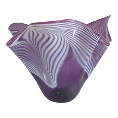 a purple vase sitting on top of a white table