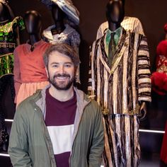 a man standing in front of some mannequins