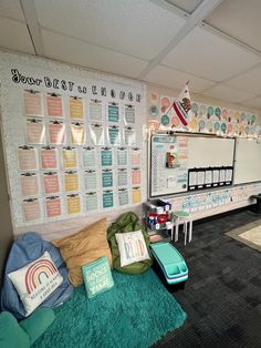 a classroom with posters on the wall and green rugs in front of desks