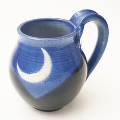 a blue and white pitcher with a crescent on it's side, sitting against a white background