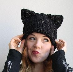 a woman wearing a black knitted cat hat