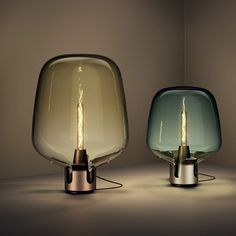 two glass lamps sitting next to each other on a table