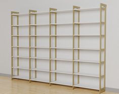 three white shelves with gold trim on each side and one empty shelf in the middle