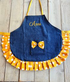 The perfect apron for your little princess!! Fits comfortably around the neck and ties in the back. Also has a pocket to store her little treasures!! The ruffled edge makes your child feel so special!!  Totally reversible and OH so adorable   The fonts are shown - select a font, or font and applique, and thread color(s) As an option, matching oven mitts, hot pads, or chef hat can be ordered and customized.  An apron set consists of apron, hat, and mitts.  Personalization included in price. Sizin Purple Apron, Boy Apron, Jean Apron, Child Apron, Toddler Apron, 1950s Sewing Patterns, Diy Pillow Covers, Simple Hand Embroidery Patterns, Diy Boho Decor