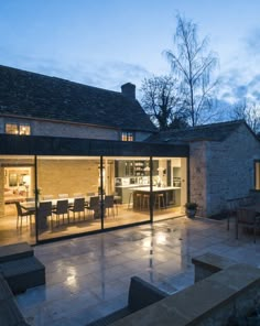 an outdoor dining area is lit up at night with lights shining on the table and chairs