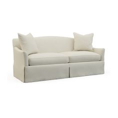 a white couch with two pillows on it's back and the seat upholstered