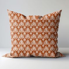 an orange and white pillow sitting on top of a table