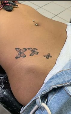 the back of a woman's stomach with three butterflies on it