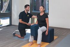 a man and woman doing yoga in an empty room